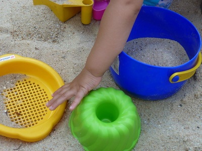 Kind spielend im Sand
