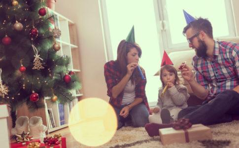 Eltern, die mit ihrem Kind gemeinsam Silvester im Wohnzimmer feiern