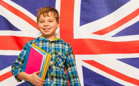 Englisch lernen - Junge mit Lernbüchern vor Großbritannien Flagge