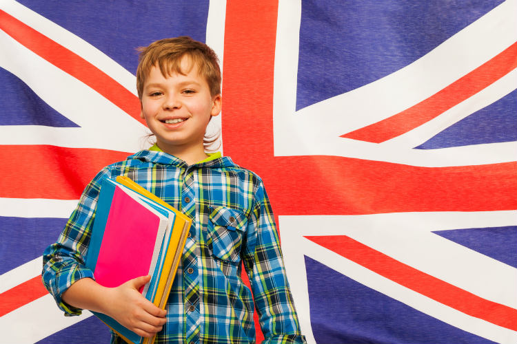 Englisch lernen - Junge mit Lernbüchern vor Großbritannien Flagge