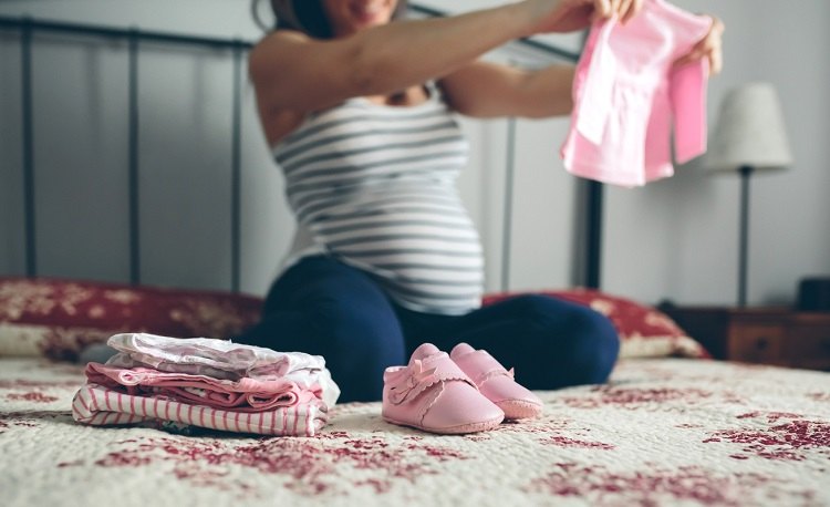 Frau such Kleidung für Baby aus