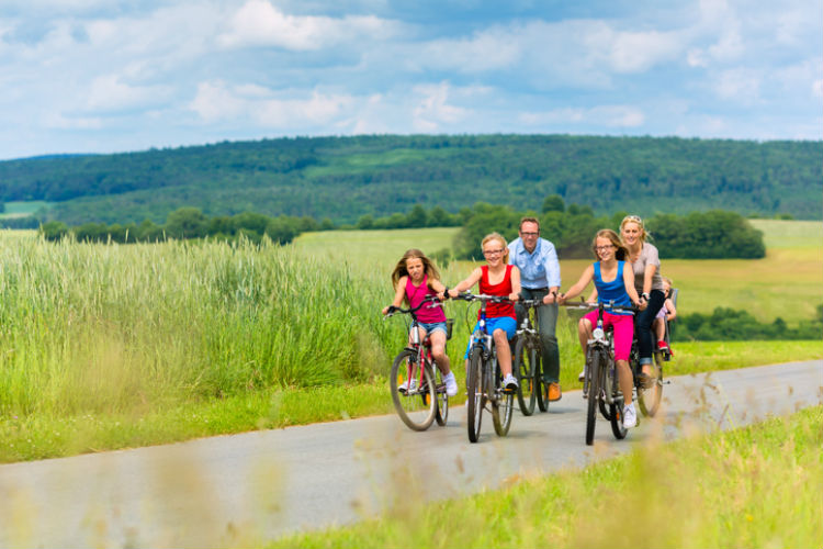 Familie, die eine Fahrradtour mit drei Kindern macht