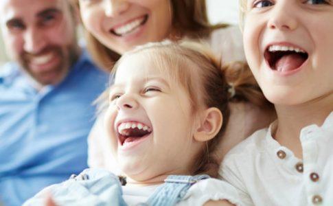 Glückliche Familie sitzt gemeinsam auf dem Sofa