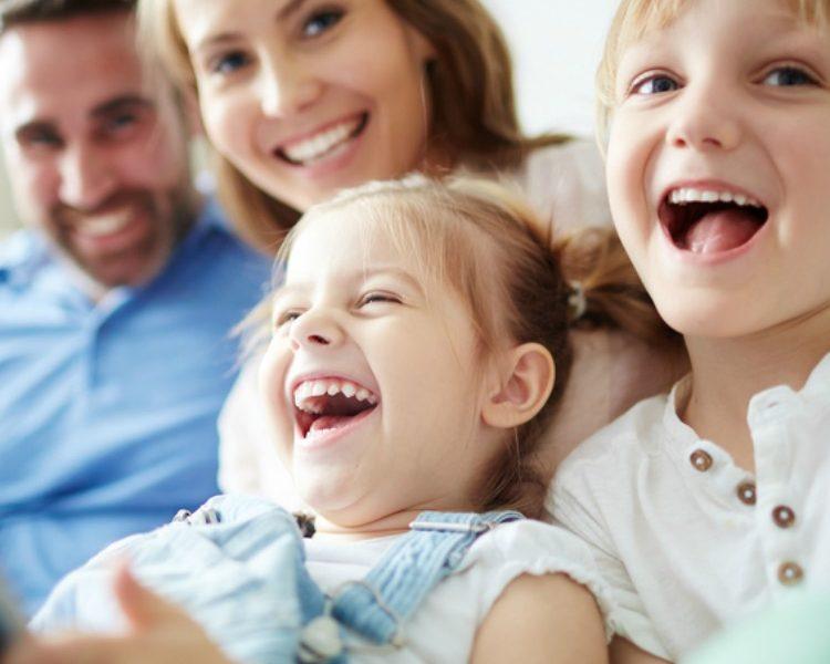 Glückliche Familie sitzt gemeinsam auf dem Sofa
