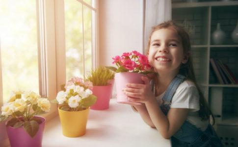 Frühling- Mädchen mit Blumen am Fenster