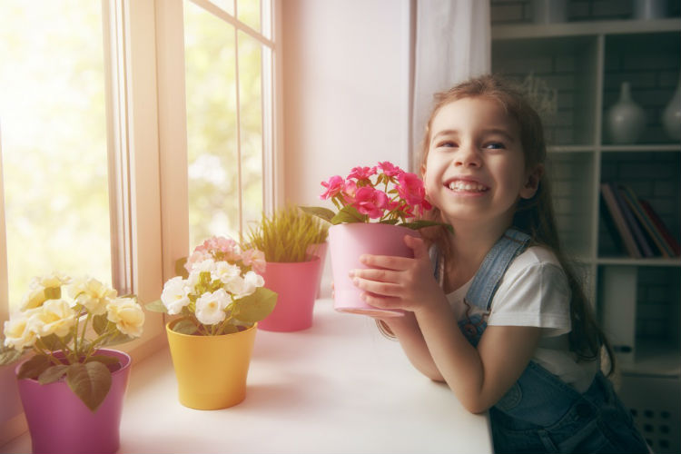 Frühling- Mädchen mit Blumen am Fenster