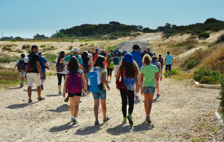 Kinder auf einer Klassenfahrt auf dem Weg zum Strand