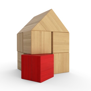 Haus aus Bauklötzchen mit einem roten Klotz