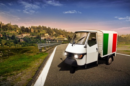 Ein kleiner italienischer Transporter steht auf einer verlassenen Straße vor herrlicher Landschaft.