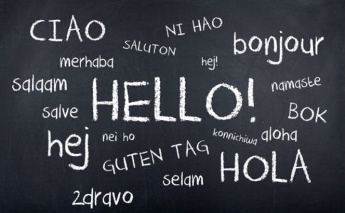 "Hallo" in verschiedenen Sprachen mit weißer Kreise auf schwarzer Tafel zur Andeutung der zweisprachigen Erziehung