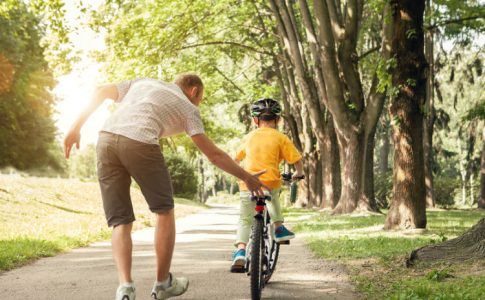 Kinde lernt Fahrradfahren mit Vater