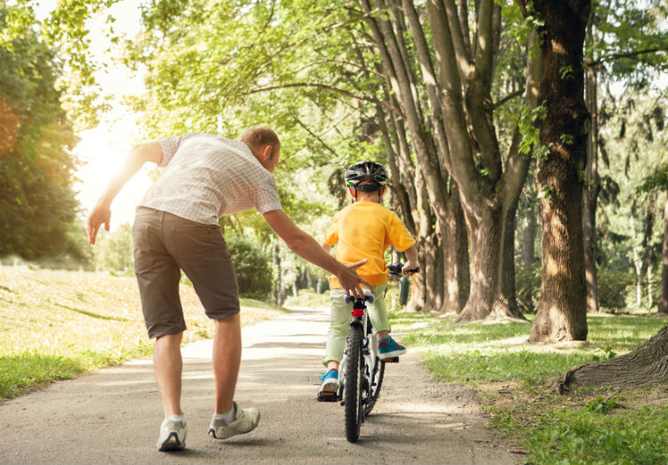 Kinde lernt Fahrradfahren mit Vater