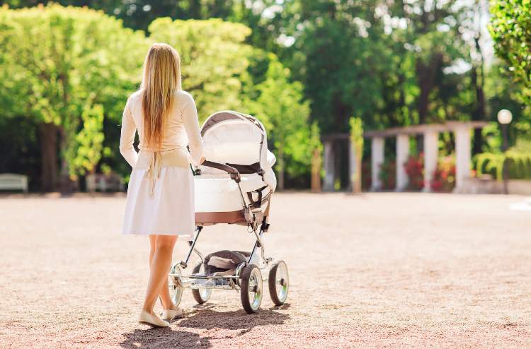 Frau schiebt einen Kinderwagen