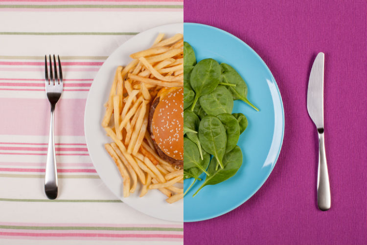 Ein Teller, auf dem auf der einen Seite Fast Food und auf der anderen Seite Salat zu sehen ist