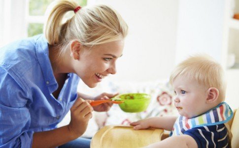 Mutter füttert Jungen mit Babybrei