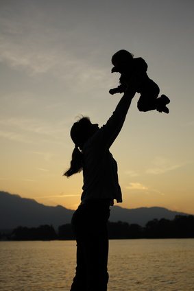Mutter wirft Kind in die Luft - Sonnenuntergang
