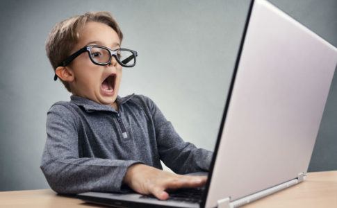 Schockiert und überrascht Junge im Internet am Laptop
