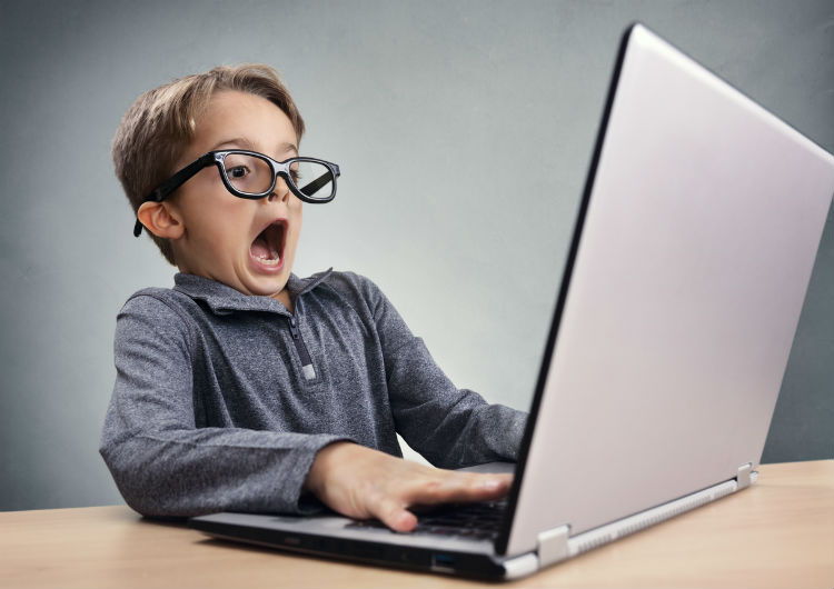Schockiert und überrascht Junge im Internet am Laptop