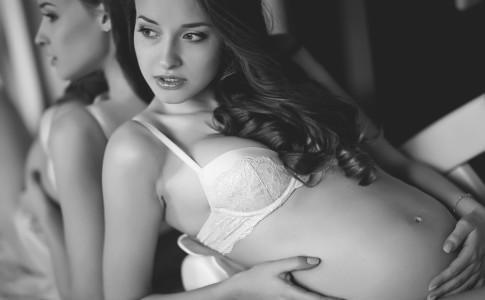 Schwangere Frau in hellen Dessous