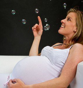 Schwangere Frau spielt mit Luftblasen