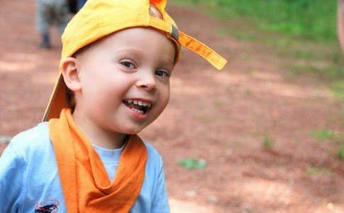 Kind lachend mit gelber Mütze