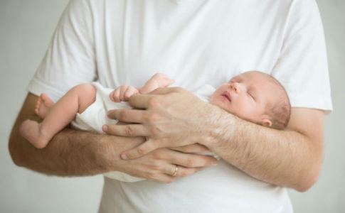 Mann, der ein Baby auf dem Arm hält