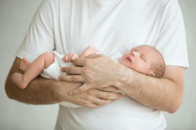 Mann, der ein Baby auf dem Arm hält