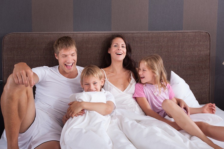 Familie gemeinsam im Hotelbett Ihres Familienzimmers