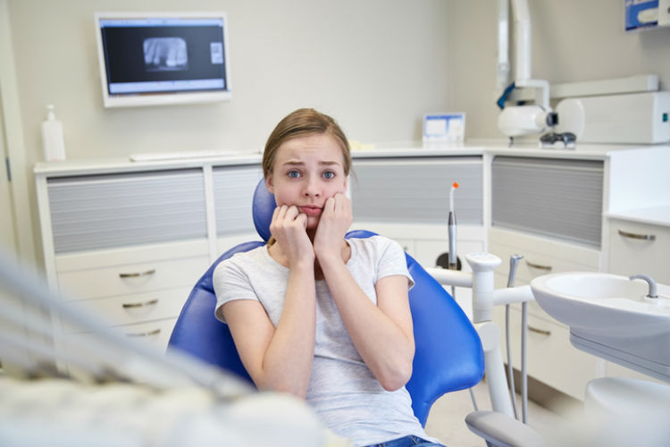 Junge Frau hat Angst beim Zahnarzt