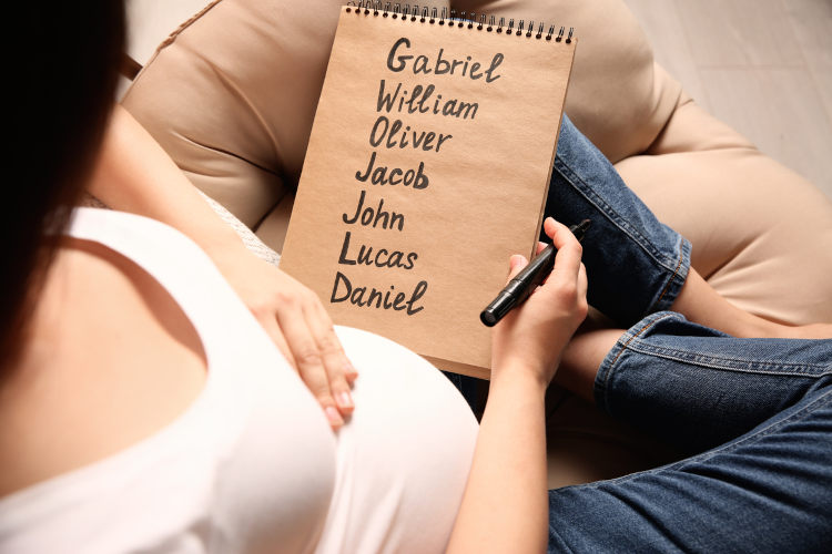 Eine schwangere Frau schreibt viele Baby-Namen auf einen Notizblock