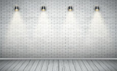 Vier Lampen hängen an einer gekachelten Wand