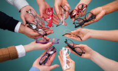 Mehrere Brillengestelle werden von verschiedenen Händen gehalten