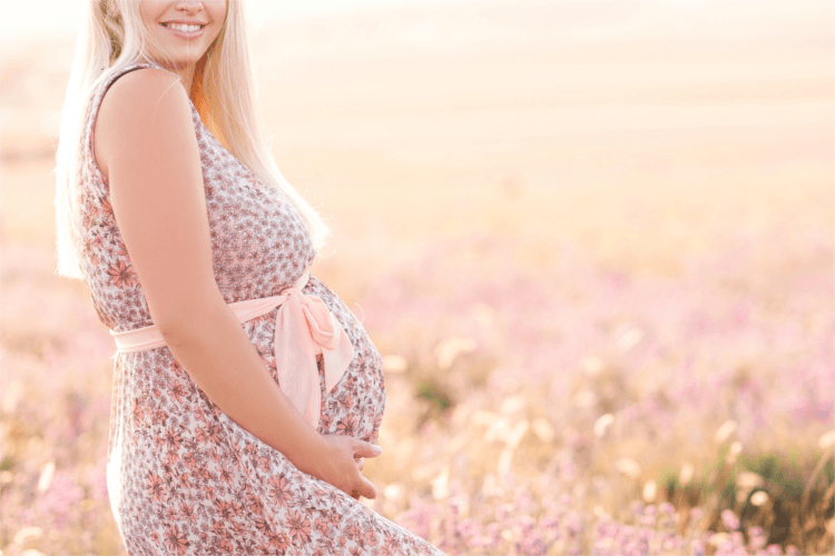 Schwangere Frau auf einer Blumenwiese