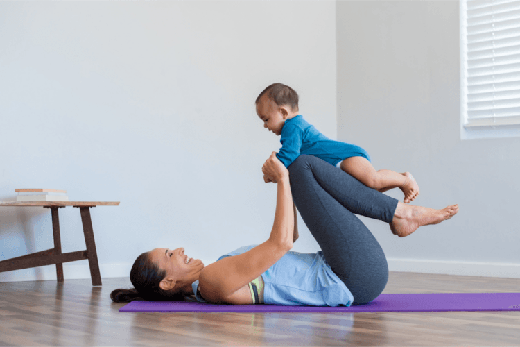 Mutter mit ihrem Baby auf einer Yoga-Matte beim Sport
