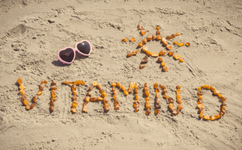 Vitamin D Schriftzug aus Steinen am Strand