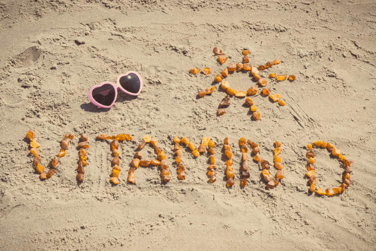 Vitamin D Schriftzug aus Steinen am Strand