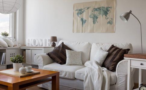 Gemütliches weißes Sofa mit Kissen und Decke