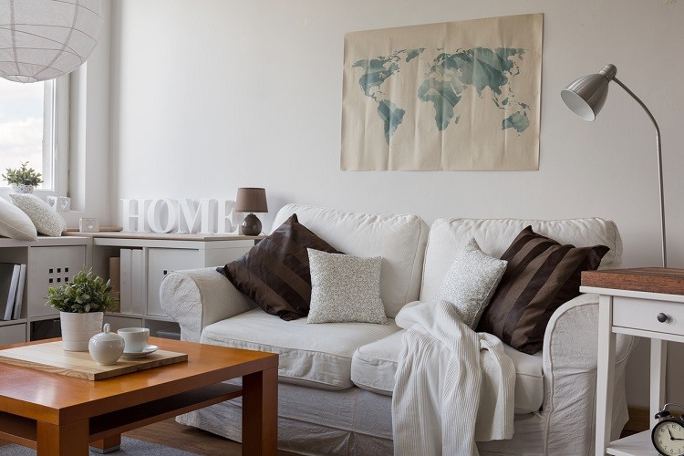 Gemütliches weißes Sofa mit Kissen und Decke