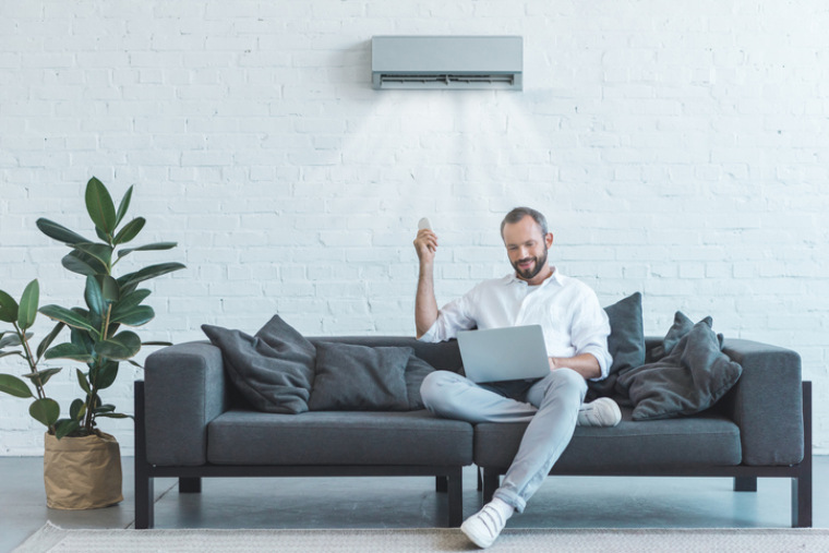 Klimaanlage vor der ein Mann sitzt
