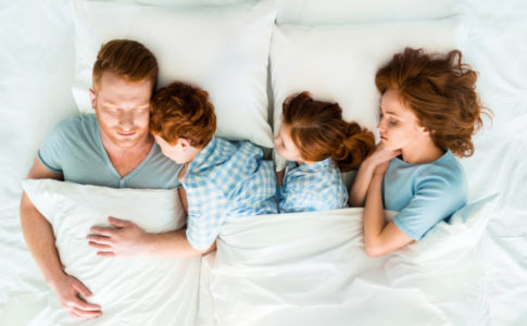 Familie liegt im Familienbett