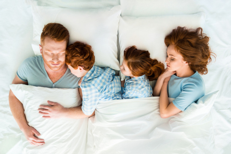 Familie liegt im Familienbett