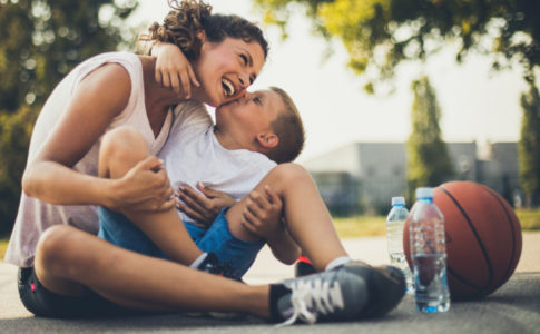 Mutter und Kind die sich vom Basketball spielen erholen