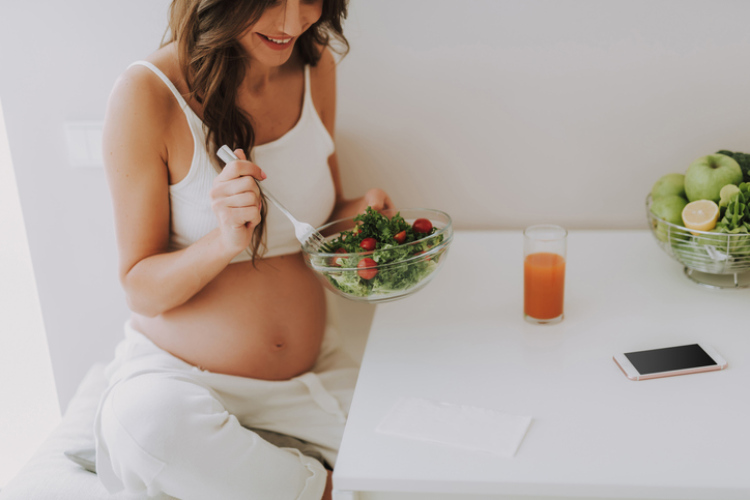 Schwangere Frau die gerade isst