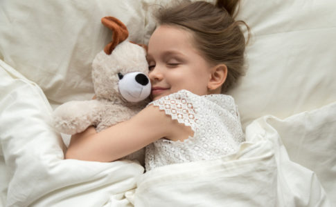 Kind welches einen Teddy umarmt