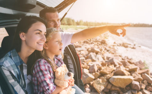 Familie sitzt im Kofferraum bei gutem Wetter