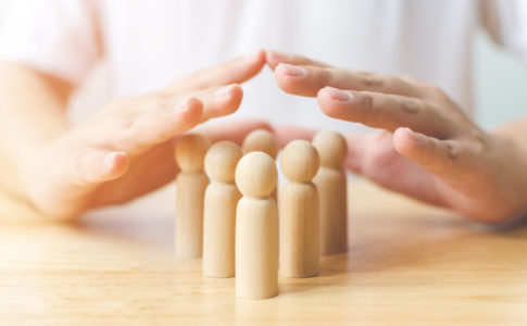 Holzfiguren die von einer Hand geschützt werden