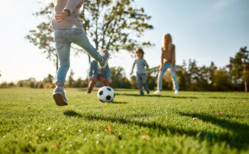 Familie spielt Fußball im Garten