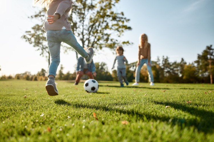 Familie spielt Fußball im Garten