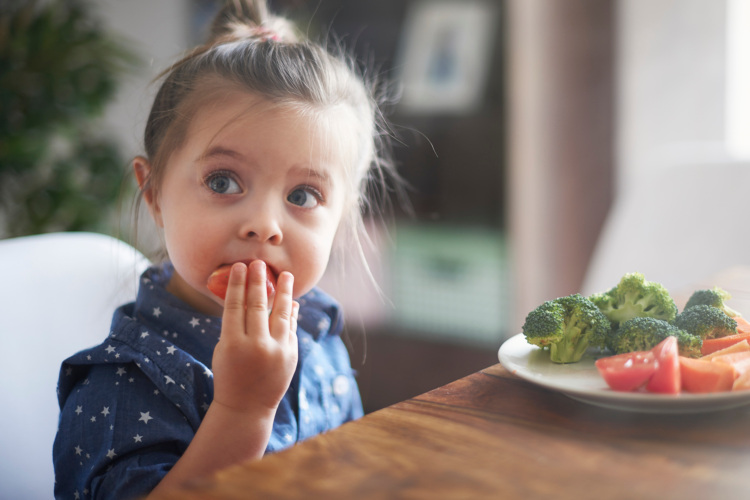 Kleines Kind isst eine Möhre