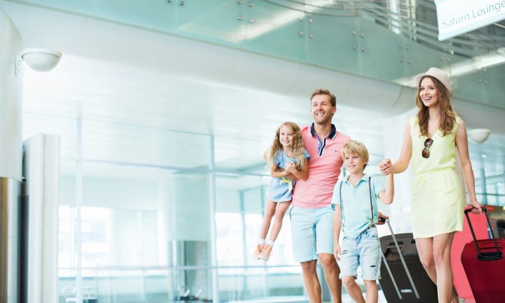 Familie mit zwei Kindern steht am Flughafen
